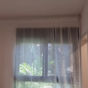 חלון עם וילון שקוף ואור שמש נכנס