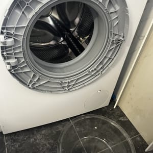 מכונת כביסה פתוחה עם קערה על הרצפה