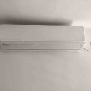 מזגן קיר לבן מחובר לשקע חשמל