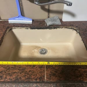 כיור מטבח עם סרט מדידה וכלי ניקוי