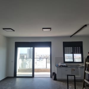 חשמלאי עובד על לוח חשמל במטבח עם סולם