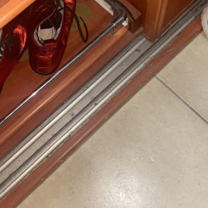 נעליים אדומות בארון עץ עם מסילות מתכת