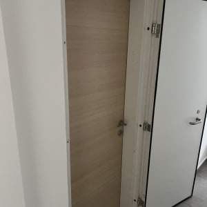 דלת עץ סגורה ודלת לבנה פתוחה עם ידית מתכת