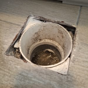 צינור פתוח ברצפה עם סימני רטיבות