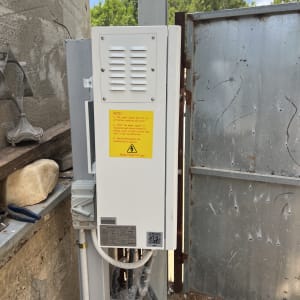 ארון חשמל עם אזהרת מתח גבוה ליד קיר בטון