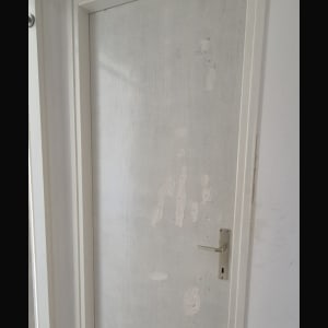 דלת לבנה עם סימני תיקון על הקיר