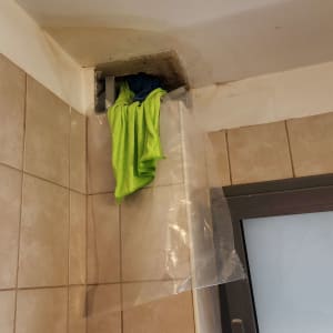 תיקון קיר עם מגבת ירוקה ופלסטיק שקוף