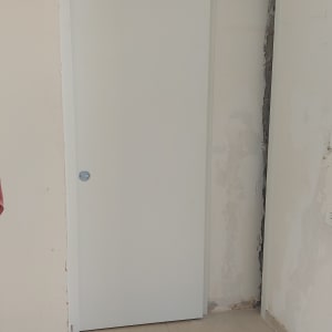 דלת הזזה לבנה בקיר עם תיקונים
