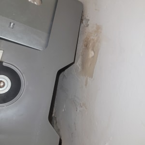 חלק ממזגן מותקן על קיר עם סימני רטיבות