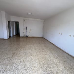 חדר ריק עם רצפת אריחים וקירות לבנים