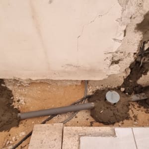 צינור ביוב מותקן בקיר עם טיח רטוב