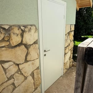 דלת לבנה עם ידית על קיר אבן