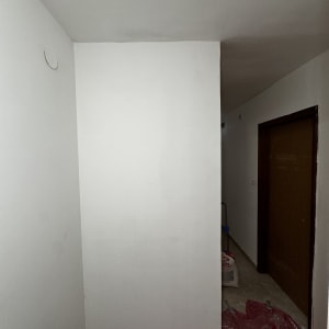 קיר צבוע עם סולם ויריעת מגן על הרצפה