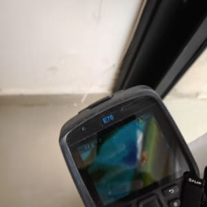 מד חום תרמי ליד קיר לבן עם סדק קטן