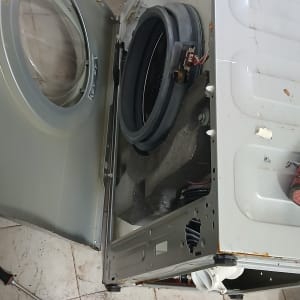 מכונת כביסה פתוחה עם כלים לתיקון