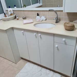 ארונות עץ לבנים עם ידיות עגולות במטבח