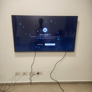 טלוויזיה מותקנת על קיר עם כבלים מחוברים לשקעים