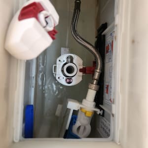 מיכל הדחה עם צינור מתכת ומנגנון פלסטיק