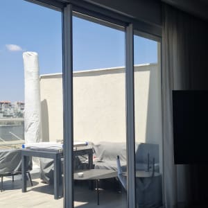 דלתות זכוכית גדולות במרפסת עם ריהוט חוץ
