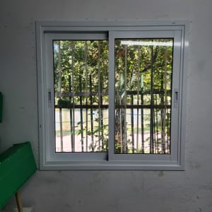 חלון אלומיניום עם מסגרת לבנה ובריחים