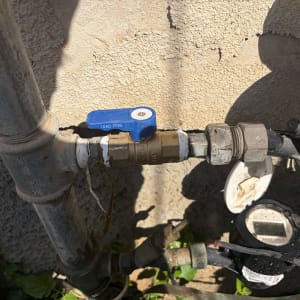 ברז מים וצנרת ליד קיר חיצוני