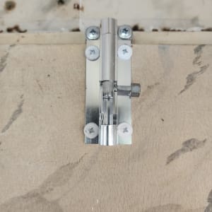 בריח מתכת מותקן על דלת עץ