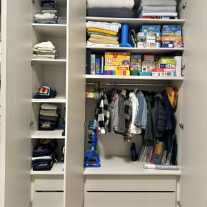 ארון בגדים מאורגן עם בגדים, משחקים ומעילים תלויים