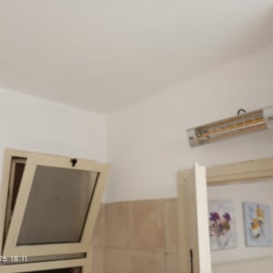 קיר צבוע עם חלון פתוח ותמונות על הקיר