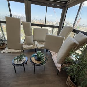 כריות ספה מונחות על כיסאות ליד חלון גדול