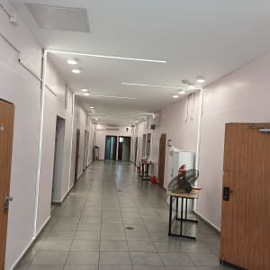 מסדרון עם קירות צבועים בלבן ודלתות עץ