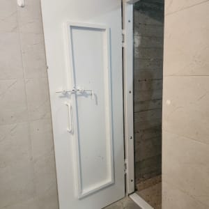 דלת לבנה מותקנת בקיר בטון