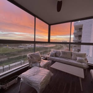 מרפסת עם ריהוט פלסטיק ונוף שקיעה