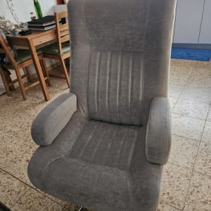 כיסא מרופד אפור בחדר עם שולחן וכיסאות