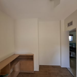 חדר עם קיר גבס ורהיט עץ בפינה