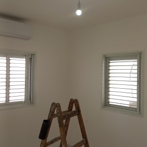 סולם עץ מתחת לנורה דולקת בתקרה