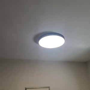 מנורת תקרה עגולה דולקת על תקרה לבנה