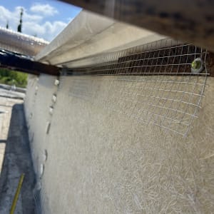 רשת מתכת מותקנת על קיר חיצוני למניעת יונים