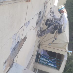 עובד בגובה על חבלים מתקן קיר חיצוני