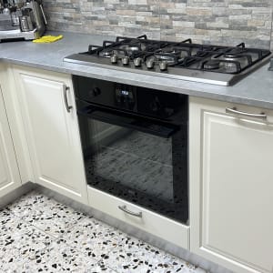 כיריים גז ותנור במטבח מודרני עם משטח עבודה אפור