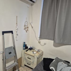 מזגן מותקן על קיר עם סולם לידו