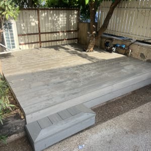 דק עץ עם עץ וצמחייה מסביב