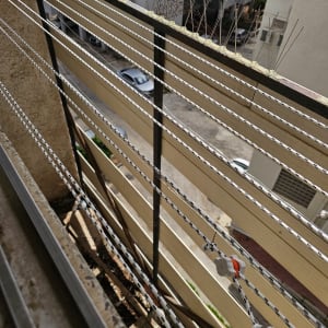 חבלים ומתקן על מרפסת עם קוצים למניעת יונים