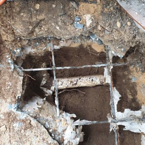 בור באדמה עם צינור חשוף ועפר מסביב