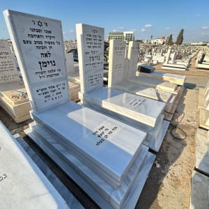 מצבות שיש בהירות מלוטשות עם כיתוב מוקפד בבית עלמין