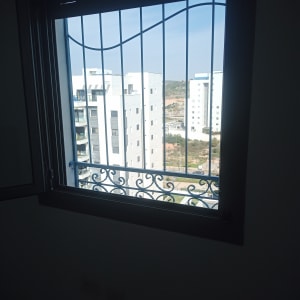 חלון עם סורגים ונוף של בניינים בחוץ