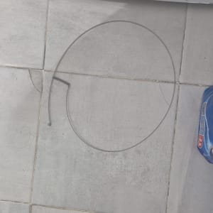 חוט מתכת על רצפת אריחים ליד נעל שחורה