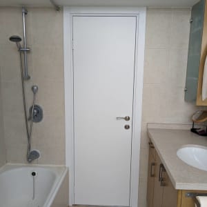 דלת לבנה עם ידית מתכת בחדר אמבטיה