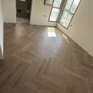 התקנת פרקט בדוגמת פישבון בחדר במהלך שיפוץ