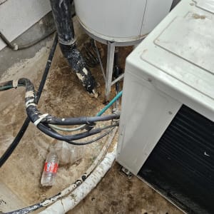 צינורות מחוברים למיכל ומזגן על רצפה רטובה