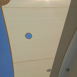 סוכך בד בהיר עם חורים עגולים בשמש